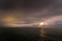 body of water under cloudy sky during sunset