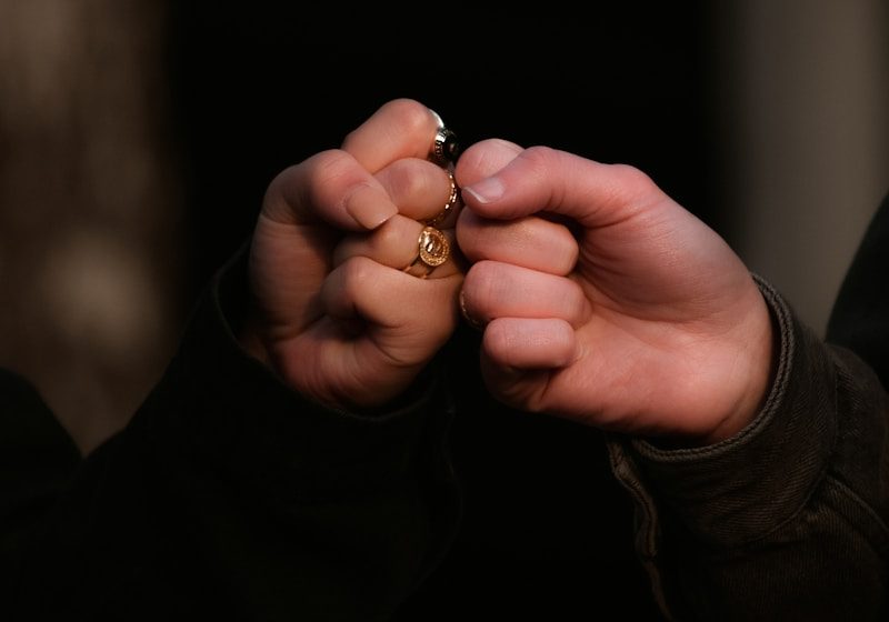 person holding gold ring in dark room